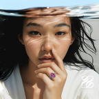 Woman with a pink ring on her finger, partially underwater with sunlight filtering through.