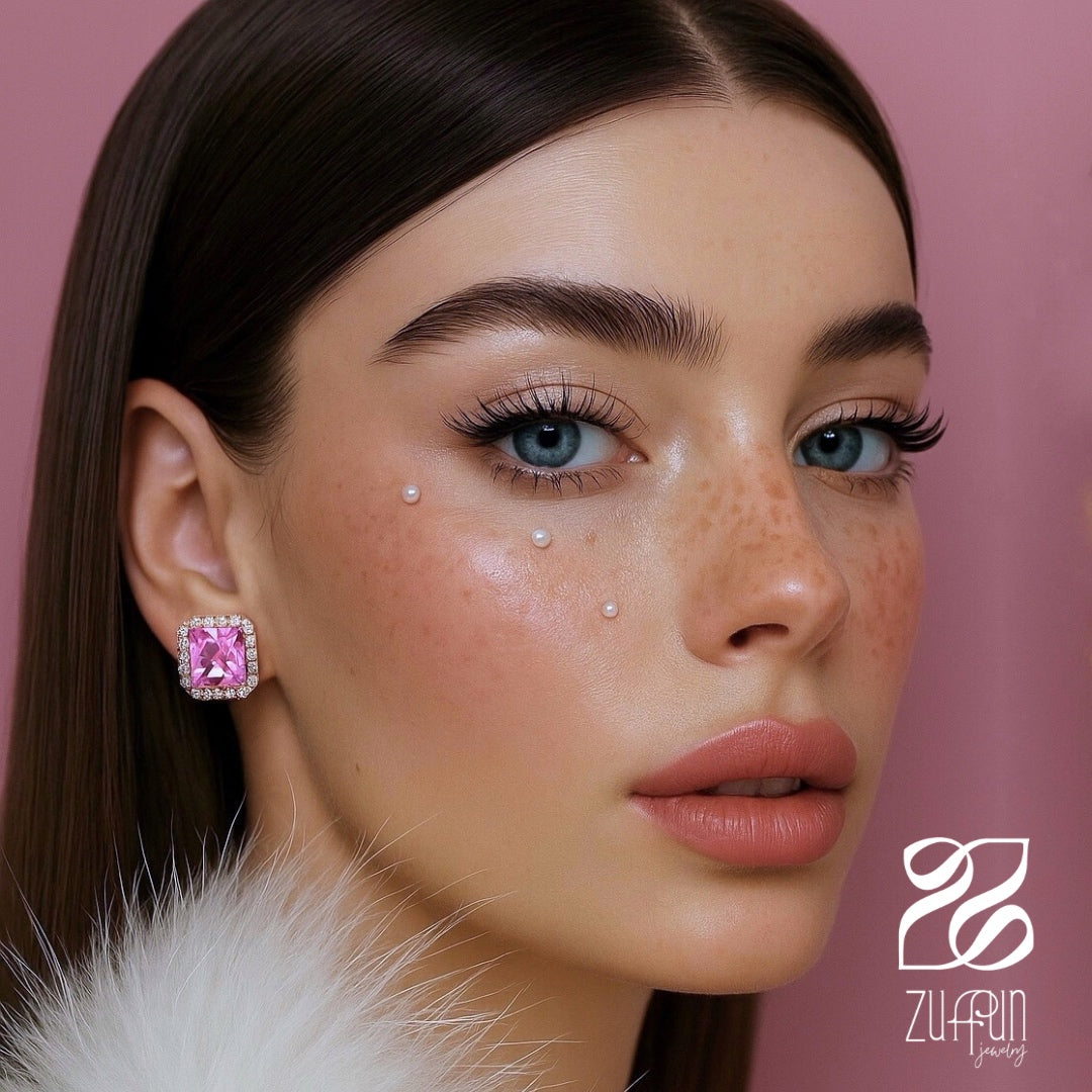 Close-up of a woman wearing pink gemstone earrings with a brand logo in the corner.