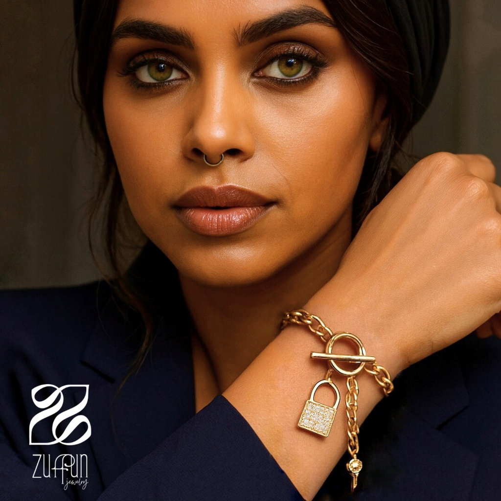 Woman wearing a gold bracelet with a lock charm, brand 'ZUFFUN' visible