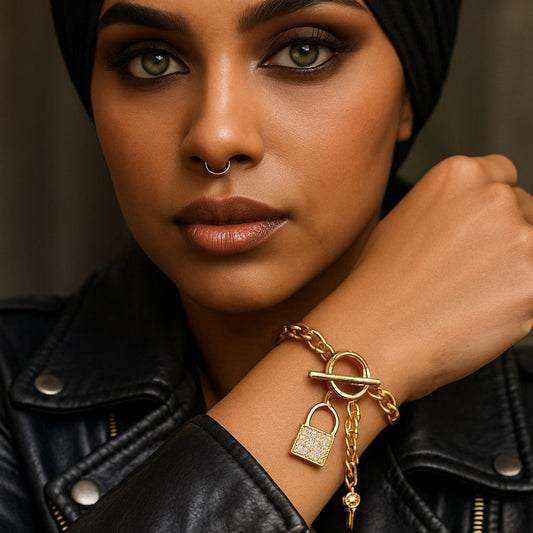 Woman wearing a black headscarf and black leather jacket with gold jewelry.